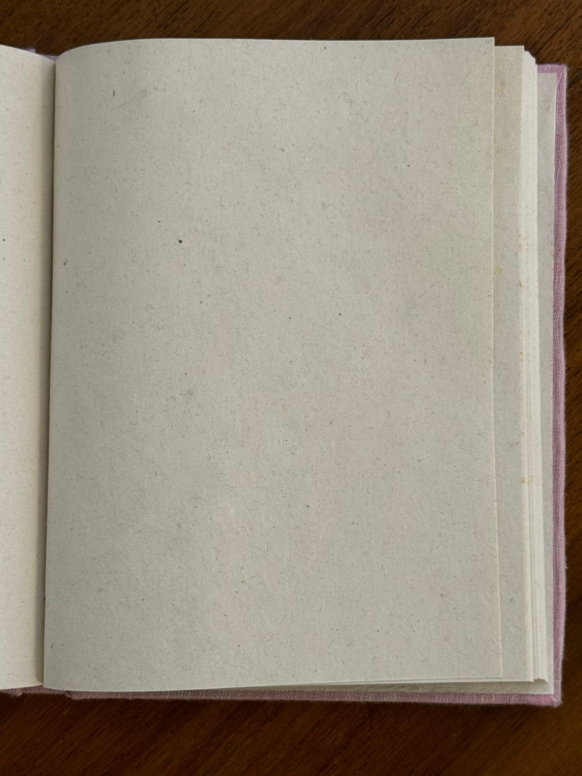 White diary with handmade sheets placed against a wooden background.