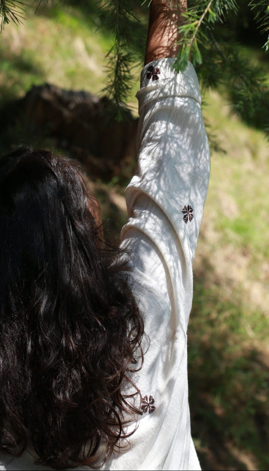 Person holding a branch of a tree in a natural setting
