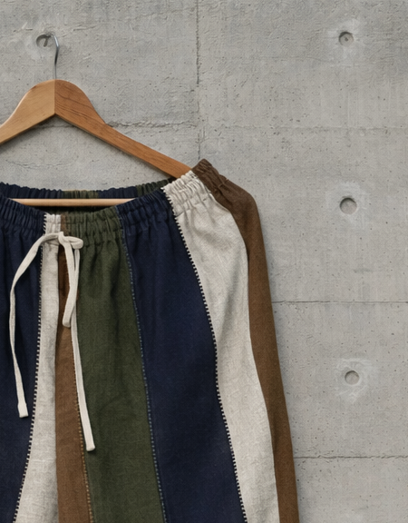 Close up of color-blocked linen pants displayed against a wall