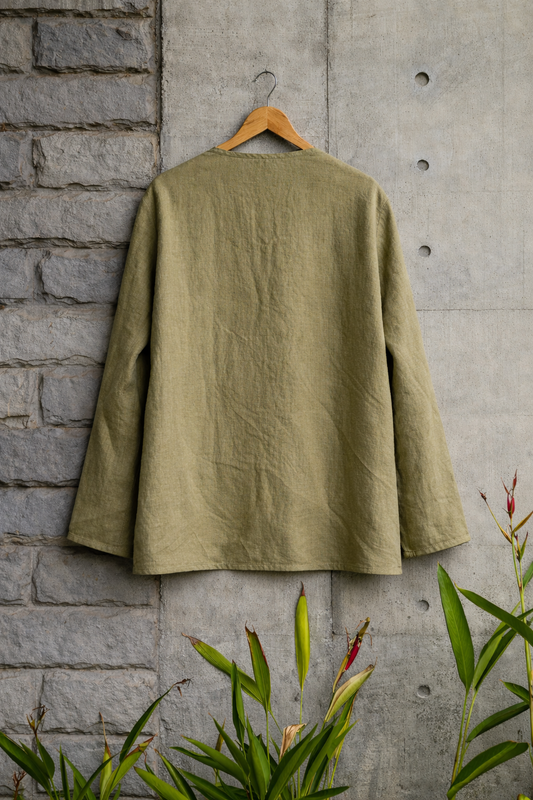 Back of Mustard Green Collarless Linen shirt displayed against a grey wall