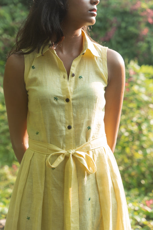 Close-up of pleats and the embroidery on yellow linen fabric