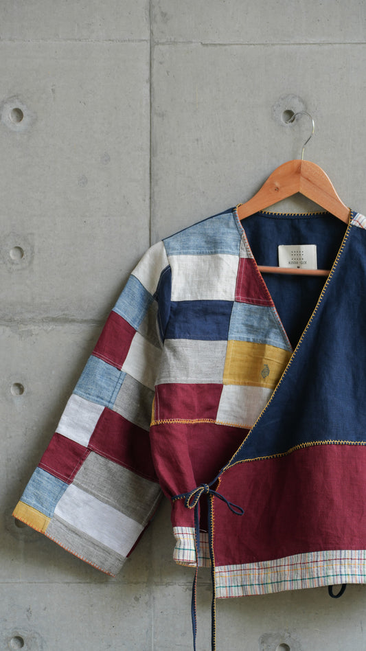 Close-up of V-neck collar and left-side tie on linen wrap shirt with patchwork detailing