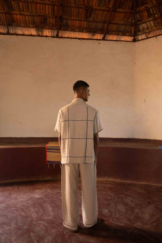 back view of Gopi, the model wearing a linen half sleeve shirt with big hand-embroidered blue checks