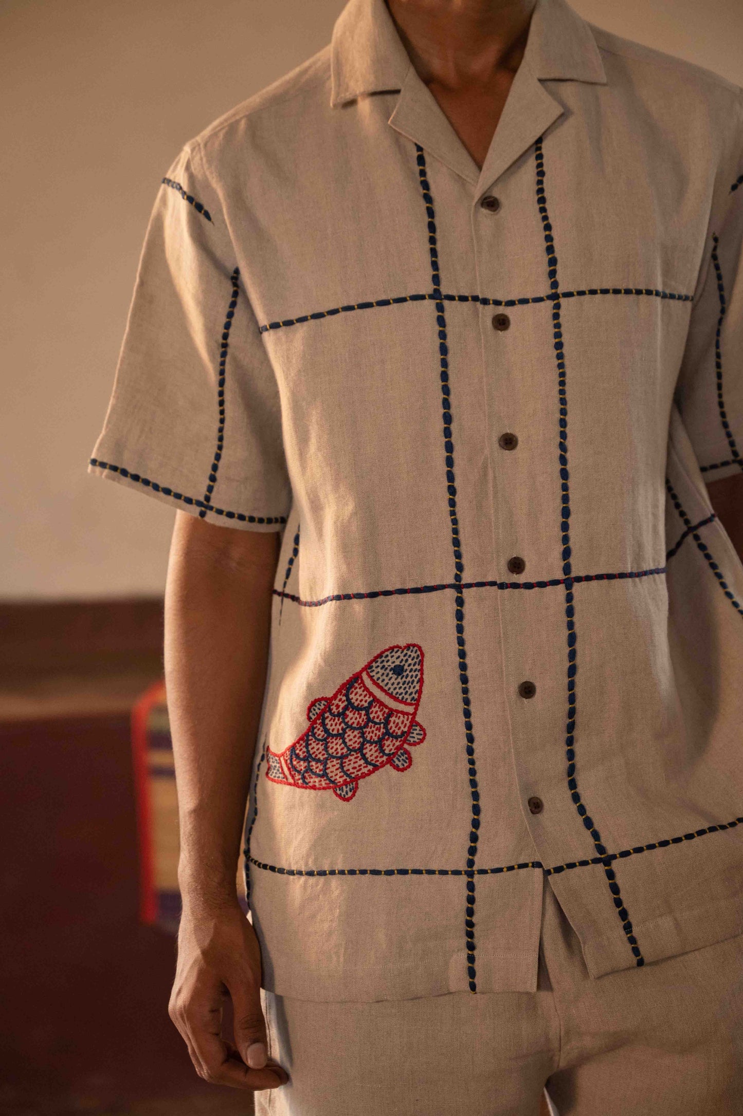 Fish detail of a linen half sleeve shirt with big hand-embroidered blue checks