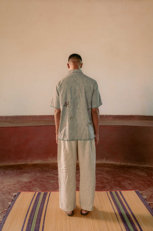 Back detail of Gopi, our model wearing a grey cotton hand-woven shirt with hand-embroidered birds