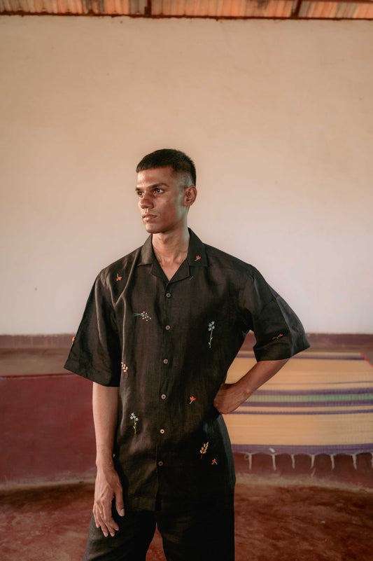 Gopi our model wearing a black linen shirt with hand-embroidered flower stalks and sprigs