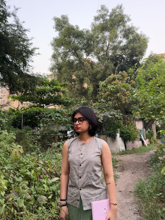 Close-up of embroidered flower details on grey cotton fabric