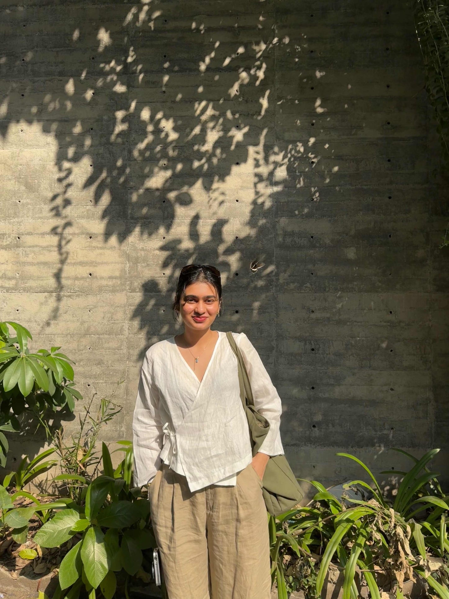 Manya wearing White Linen Wrap Top with left-side tie and criss-cross front flaps