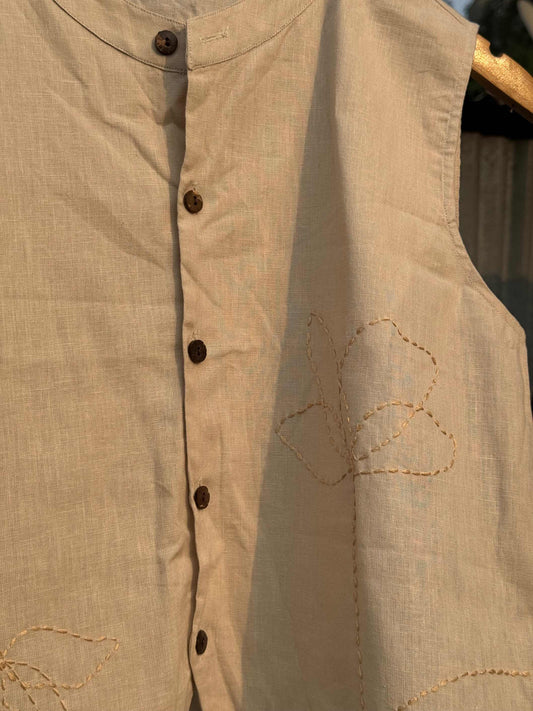 Close-up of embroidered flower details on off-white linen fabric