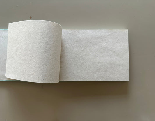 White diary with handmade sheets placed against a light background