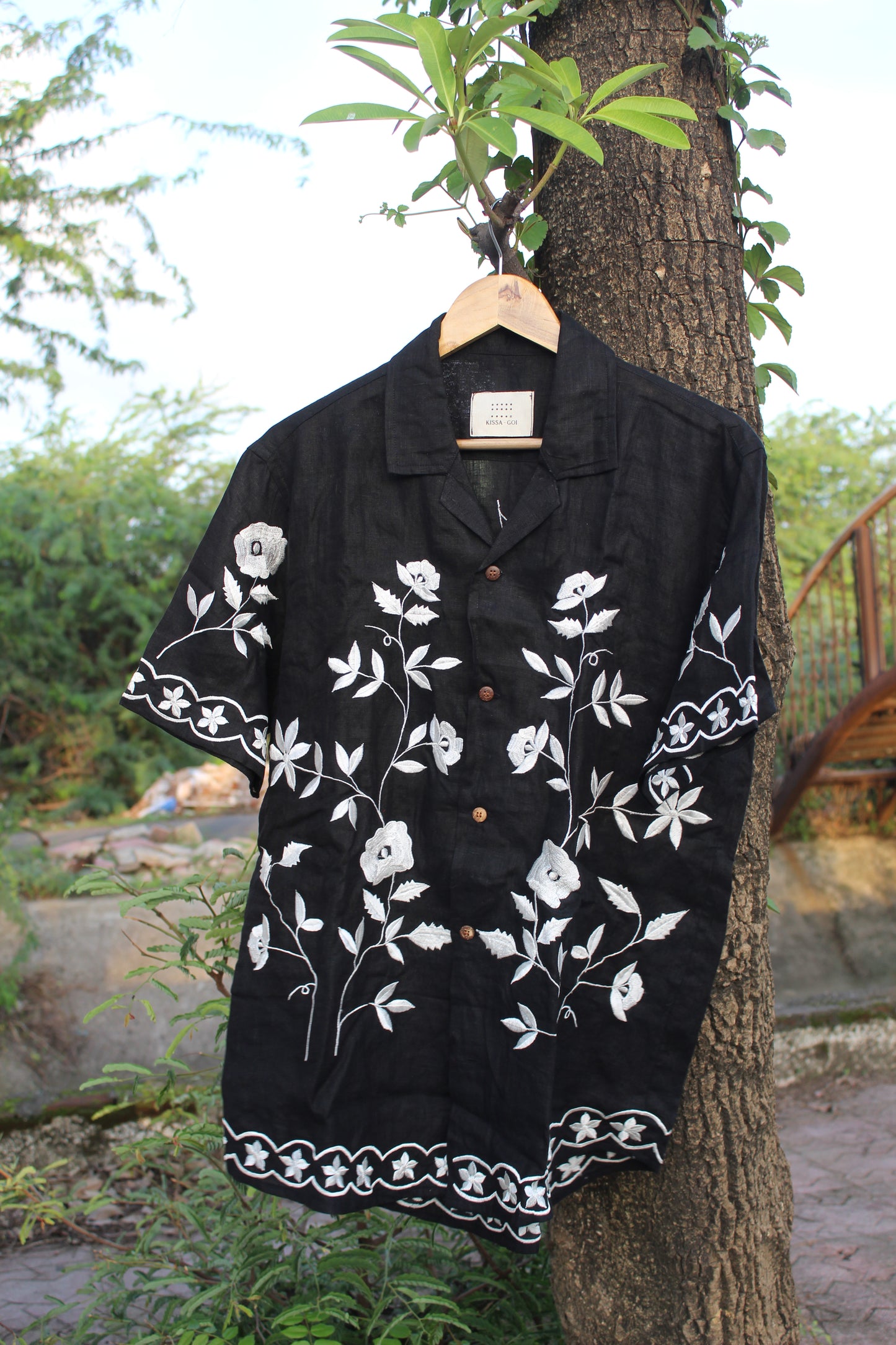Front view of a black linen half sleeved shirt with off-white floral embroidery