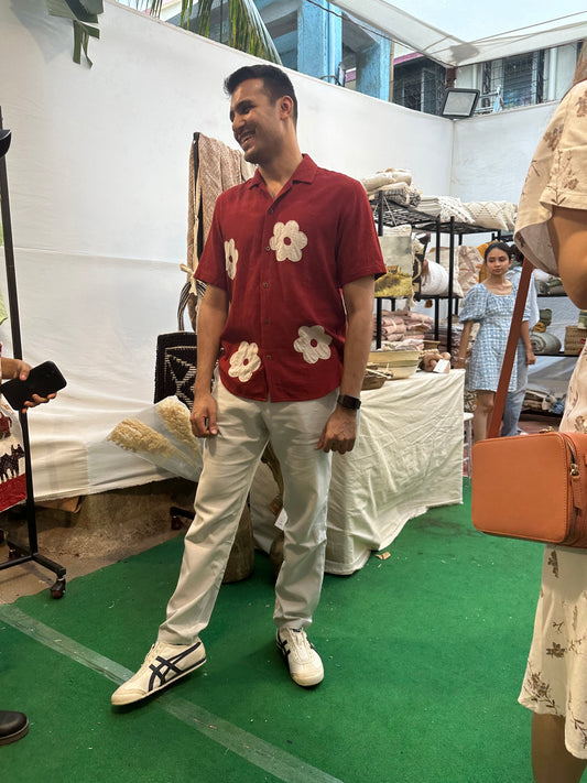 Siddharth wearing a red linen shirt with patchwork off-white flowers