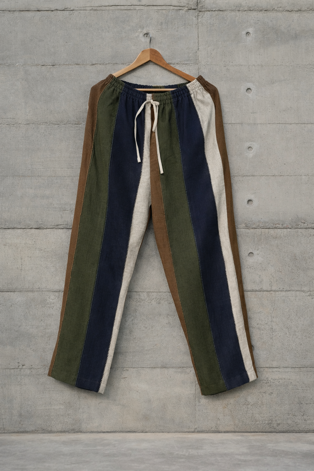 Color-blocked linen pants displayed against a wall