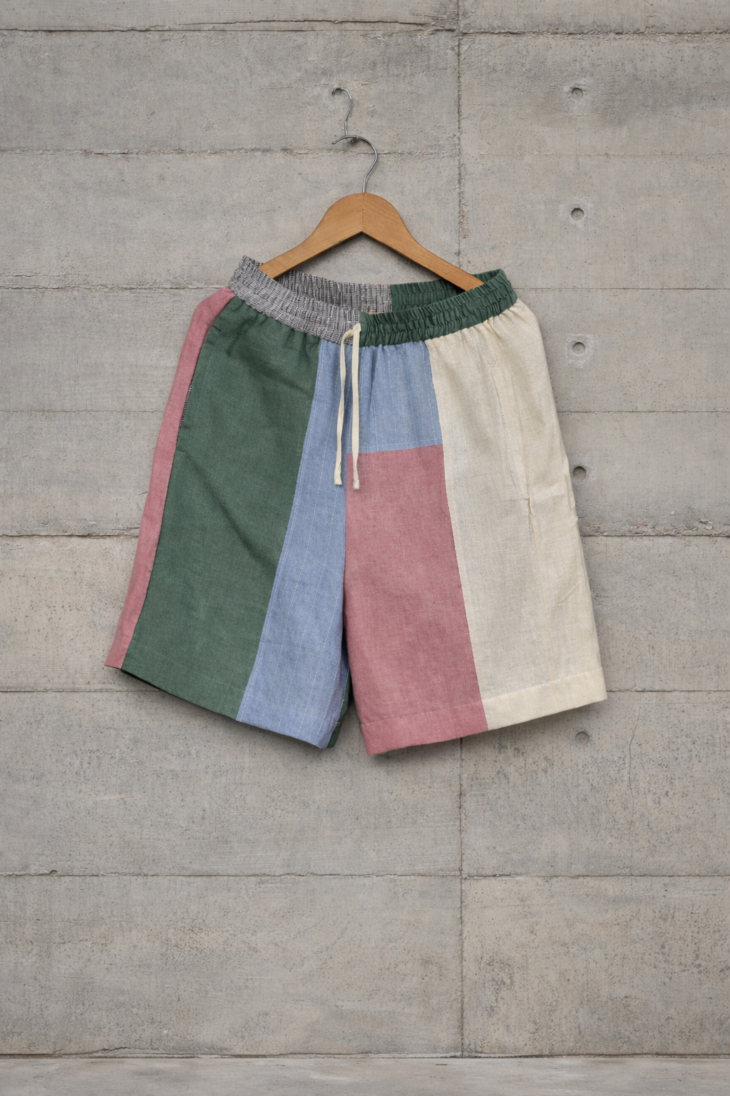 Patchwork linen shorts displayed against a wall