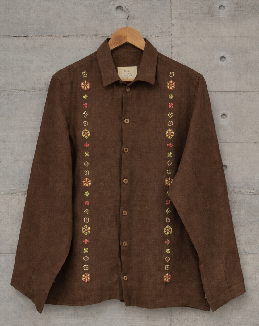 Brown jacket with zari flower motif displayed against the wall.