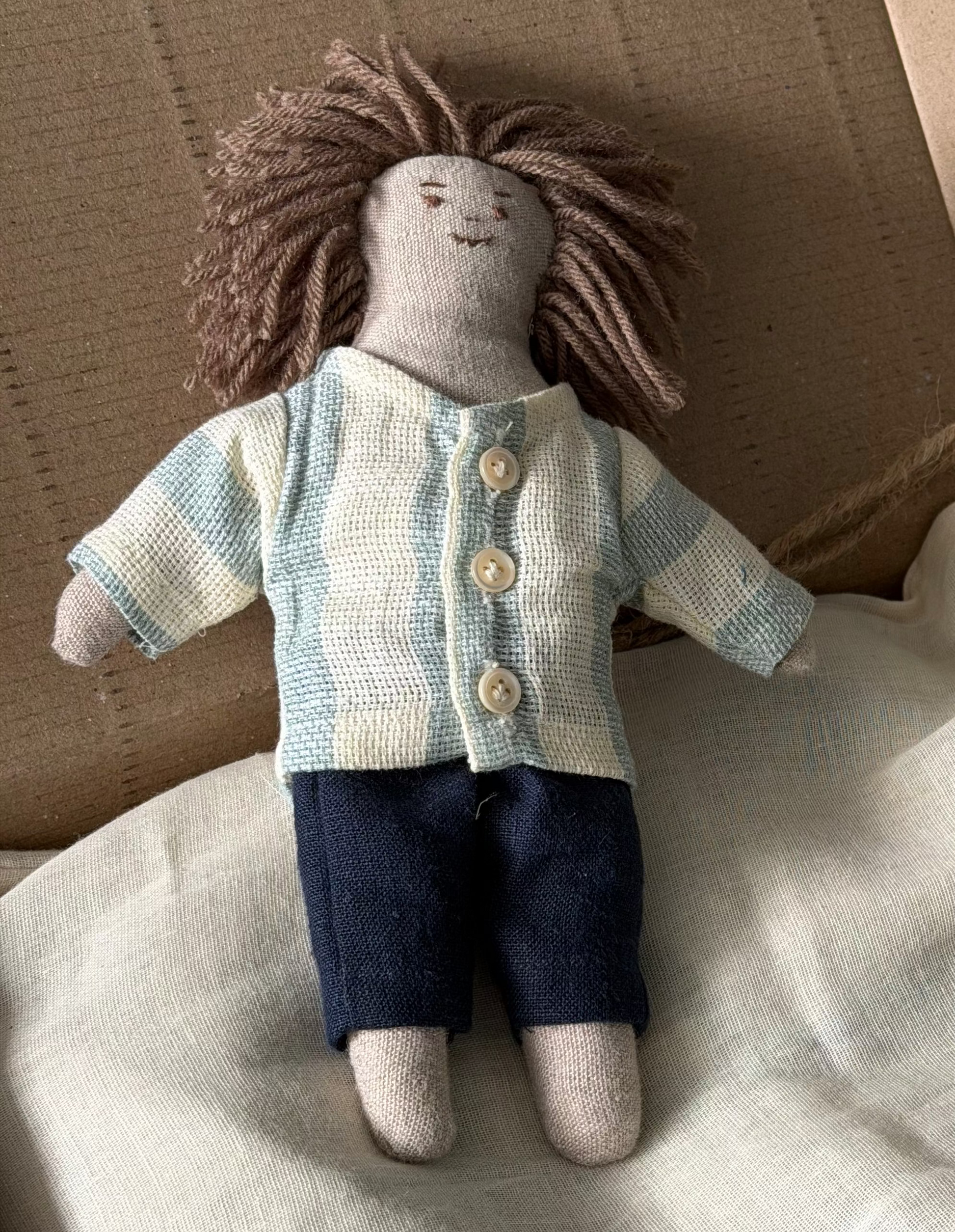 The first friend doll hand-stitched closeup placed on a cardboard box