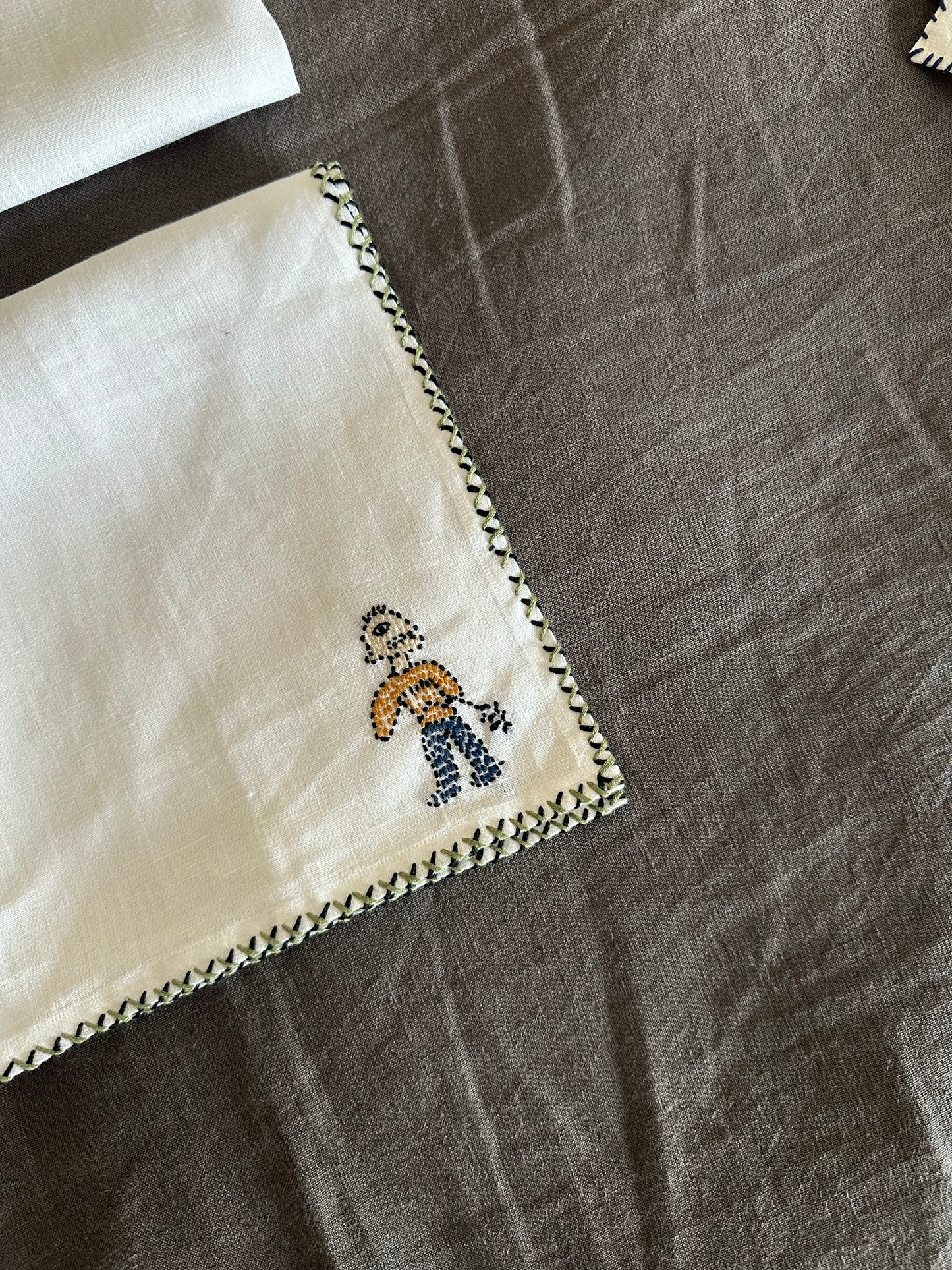 White napkin with embroidered design on a linen fabric